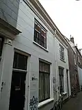 Woonhuis, in blokje van twee gespiegelde huizen, 19de-eeuws van karakter, in traditioneel-classicistische vormen. Het is van belang als gaaf bewaard voorbeeld van een 'arbeiderswoning' met twee bouwlagen.