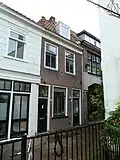 Pand met beneden- en bovenwoning, mogelijk vroeg-19de-eeuws of laat-18de-eeuws in sobere traditionele vormen. Voorgevel waarschijnlijk tegelijk met die van het links belendende pand ontstaan.