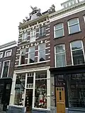 Winkelwoonhuis, in 1894 gebouwd in een eclectische stijl met neo-renaissance elementen. Winkelpui uit 1960. Het is typologisch van belang als voorbeeld van een winkelwoonhuis met opslagzolders. Het is van belang als goed voorbeeld van de eclectische bouwstijl, geïnspireerd op de Hollandse renaissance, zoals die rond 1900 in zwang was.