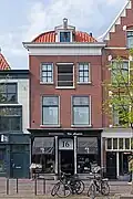 Winkelwoonhuis in eclectisch-classicistische vormen uit ca. 1900. Het is typologisch van belang als voorbeeld van een winkelwoonhuis met pakhuisverdieping. De gevel is een goed voorbeeld van een sobere eclectisch-classicistische bouwstijl met een overwegend gaaf bewaarde goed vormgegeven pui.