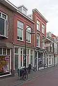 Pand, in oorsprong winkel-woonhuis, rond 1900 gebouwd in een traditionalistische trant.