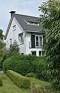 Vrijstaande wit gepleisterde villa, rond 1930 ontworpen door architectenbureau Granpré Molière Verhagen en Kok te Rotterdam, met P. Verhagen als de projectarchitect.