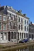 Woonhuis in blokje van drie woningen met een voorgevel in rijke eclectische bouwtrant, in 1884 gebouwd door aannemer G. de Ronde. Het blokje is symmetrisch opgezet met een accent op het middelste pand waarvan de gevel als risaliet naar voren springt en iets rijker is behandeld. Het pand is van belang als onderdeel van het blokje Oude Delft 12/12a/12b.