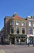 Winkelwoonhuis, in het laatste kwart van de 19de eeuw gebouwd, mogelijk in 1884, in een sobere eclectisch-classicistische bouwtrant. Het voorhuis is van belang als goed en gaaf bewaard winkelpand in een verorgde sobere eclectisch-classicistische architectuur met een bijzondere hoekoplossing.