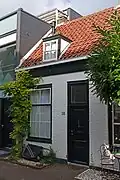 Pand in rijtje van vier, in opzet identieke, traditioneel vormgegeven woningen uit de 19e eeuw, Pluympot 4t/m 10.