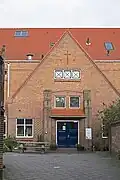 Pand, in 1919 gebouwd als RK Parochiale jongensschool naar een ontwerp van J.Th. van Rossum in een aan de Amsterdamse School verwante bouwstijl.