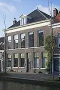 Complex van een voormalige stadsboerderij bestaande uit een woonhuis, met daarmee verbonden bedrijfsbebouwing, onder meer stallen, en links op het erf een kleine vrijstaande stal of schuur. Het complex dateert hoofdzakelijk uit het derde kwart van de 19e eeuw. Het woonhuis is gebouwd in een sobere traditioneel-classicistische bouwtrant. De overige bebouwing van het complex is uitgevoerd in zeer sobere traditionele en utilitaire vormen. Achter in het woonhuis bevindt zich een onderkelderd gedeelte met opkamer, dat in oorsprong ouder is. De voormalige boerderij is aangepast aan een woonfunctie.