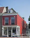 Winkelwoonhuis op de noordelijke hoek van Verwersdijk en Rietveld, in 1889 gebouwd in een sobere eclectisch-classicistische stijl.