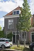 Pand met twee woningen, met voorgevel uit de late 19e eeuw. Blijkens de vrij liggende linker zijgevel die op de begane grond oud metselwerk toont, is het pand in oorsprong ouder.