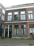 Beneden- en bovenwoning in blokje van twee benedenwoningen en twee bovenwoningen uit het laatste kwart van de 19de eeuw in sobere classicistische vormen.