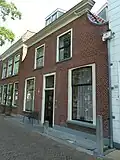 Woonhuis, vroeger dubbel woonhuis met de woningscheiding in het vlak onder de nok, 19de-eeuws van karakter, in oorsprong mogelijk ouder. Het pand is voor de gemeente delft van algemeen belang vanwege de cultuurhistorische waarde.
