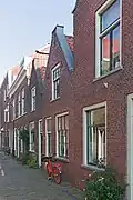 Woonhuis in blokje van twee gespiegelde woningen in traditionele vormen, uit begin 19de of eind 18de eeuw.
