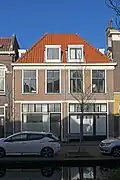 Woonhuis, vermoedelijk uit de tweede helft van de 17e eeuw, in sobere classicistische vormen met oorspronkelijk een rechte gevelbeëindiging. Pui gewijzigd in 1926. Het pand is van groot algemeen belang voor de gemeente Delft vanwege de cultuurhistorische en architectuurhistorische waarde. Het is een in Delft zeldzaam voorbeeld van een sober classicistisch woonhuis van middelgrote afmetingen uit de late 17e eeuw.