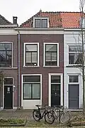 Woonhuis, gebruikt of verbouwd geweest als bedrijfspand met bovenwoning. Voorgevel mogelijk uit de eerste helft van de 19e eeuw, pand zelf in opzet mogelijk ouder.