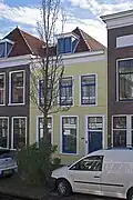 Woonhuis, in oorsprong wellicht 17e-eeuws of ouder, voorgevel in de 19e eeuw in een traditionalistisch-classicistische trant gewijzigd of vernieuwd.