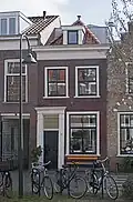 Woonhuis, laat-18e- of vroeg-19e-eeuws van karakter maar in oorsprong ouder en van eenzelfde opzet als het rechts belendende pand. Het pand is voor de gemeente Delft van algemeen belang vanwege de cultuurhistorische waarde