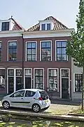 Pand met beneden-en bovenwoning uit de tweede helft van de 19e eeuw, in een sobere traditioneel-classicistische bouwtrant.
