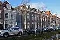 Woonhuis, onderdeel van rijtje van drie identieke huizen, in het laatste kwart van de 19de eeuw gebouwd in traditioneel classicistische vormen, ter plaatse van de uit 1836 daterende en in 1886 afgebroken St. Hippolytuskerk.