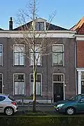Woonhuis, onderdeel van rijtje van drie identieke huizen, in het laatste kwart van de 19de eeuw, gebouwd in traditioneel classicistische vormen, ter plaatse van de uit 1836 daterende en in 1886 afgebroken St. Hippolytuskerk.