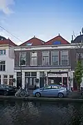 Dubbelpand met op de begane grond winkel-/bedrijfsruimte en daarboven woningen. Voorgevel uit het laatste kwart van de 19e eeuw, in en sobere traditionalistisch-classicistische architectuur.