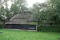 Boerderij onder met riet en pannen gedekt wolfdak. In de voorgevel vensters met luiken en schuiframen met 20- en 25-ruitsroedenverdeling. Deur uit de bouwtijd met eenvoudig bovenlicht