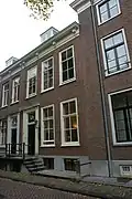 Pand voorzien van gevel met kroonlijst op gesneden consoles, deuromlijsting met pilasters