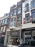 Drie assen breed winkel/woonpand op rechthoekige plattegrond bestaande uit drie bouwlagen onder een kapverdieping art nouveau, Weense Sezession stijl