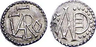 Munt van Karloman I, geslagen in Angers. De voorzijde bevat de tekst CARLO, de achterzijde het monogram MANDE