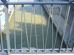 Detail van de Snelbinder, met het woord "WAAL" in spiegelbeeld gevormd door de spijlen in het hek