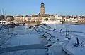 Gezicht op Deventer in de winter, met kleine ijsschotsen aan de oever