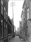 Gezicht in de Diefsteeg vanaf de Breestraat naar de Pieterskerkgracht. Op straat twee melkbussen op een kar. Circa 1905.