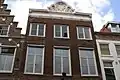 Pand met lijstgevel met verhoogd middenstuk in Lodewijk XIV-trant en met jongere onderpui[5]