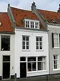 Huis met gepleisterde lijstgevel met oude scheidsmuur