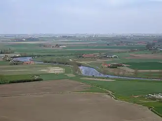 Zicht op de Polders rond Diksmuide; centraal de IJzer; aan de horizon de Belgische kust