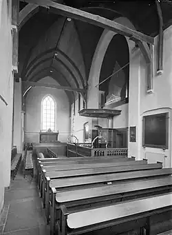 Interieur dwarsschip in noordelijke richting (1935): afgesloten koorwand met preekstoel en orgel