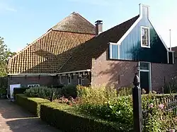 Stolp met centraal geplaatst voorhuis met schoorsteen te Assendelft.