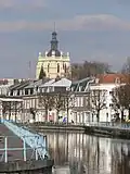 De kerktoren met op de voorgrond, de rivier de Scarpe die de stad groot heeft gemaakt