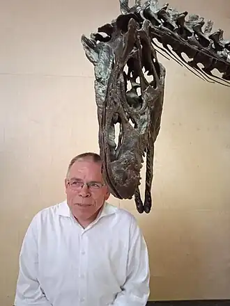 Dr. Eric Mulder poseert met een Allosaurus.