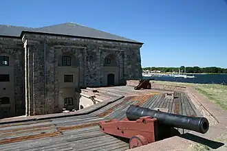 Opgestelde kanonnen en de zeezijde van de gebouwen