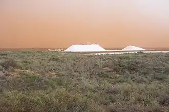 zoutwinning met zandstorm op de achtergrond