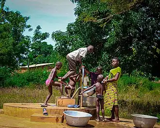 Dorpsbevolking bij de waterpomp