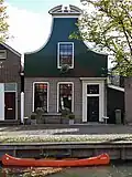 Huis met houten door een gebroken fronton bekroonde klokgevel