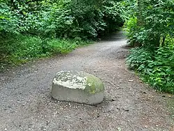 Een jumboblok aan het begin van een bospad (bedoeld om het vrij te houden van auto's)