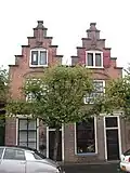 Huis met trapgevel, toppilaster op een maskerkraagsteen. Tweelichtzoldervensters, met een luik van geprofileerde planken. Gewijzigde pui. Trapgevel gekoppeld met die van buurnummer 8