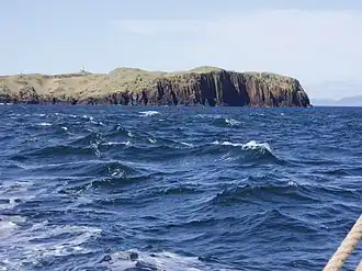 Foto van het eiland, met de vuurtoren zichtbaar.