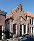 Huis met puntgevel met toppilaster en hoekpilasters onder aan de top