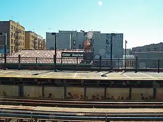 Het perron en stationsbord met op de achtergrond een aantal flatgebouwen (2007)