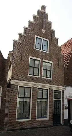 Pand met bakstenen trapgevel met toppilaster