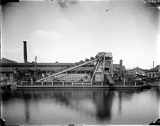 Baggervaartuig Hollands Diep 4 voor de wal van het fabrieksterrein