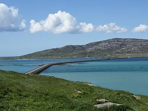 De stenen dam met weg die Eriskay met South Uist verbindt